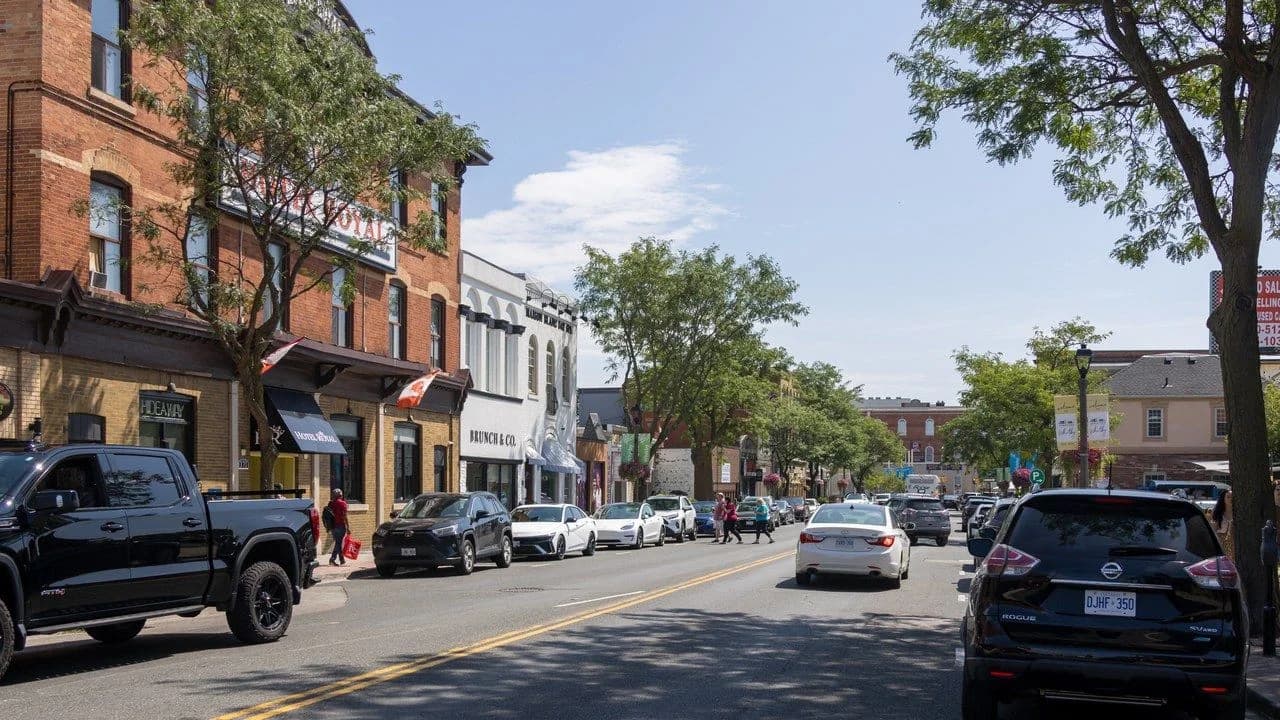 Looking south along Brock Street in downtown Whitby; storefronts and parked cars, no identifiable people