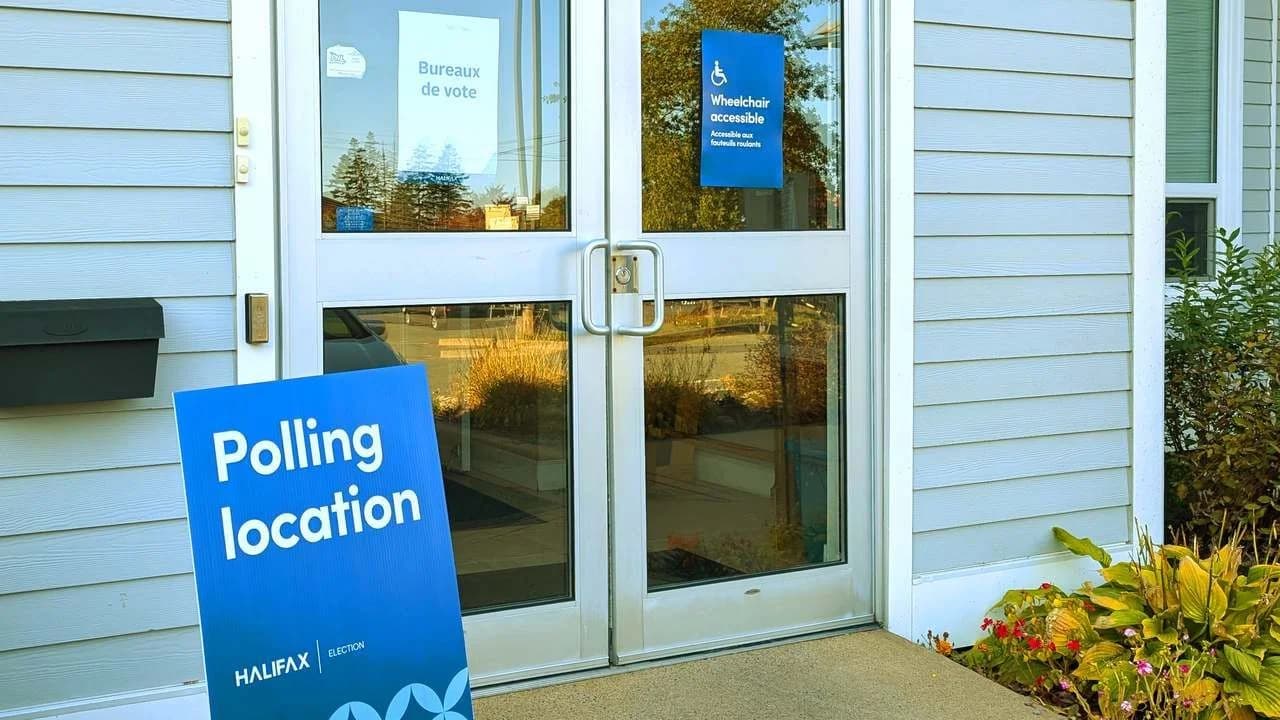 Entrance of a Canadian municipal election polling location with a blue Polling location sign and bilingual Bureaux de vote notice; file photo, no people visible.
